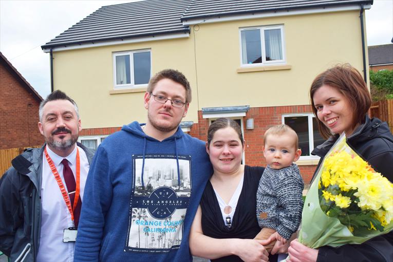 Young family with Trust staff at their new home