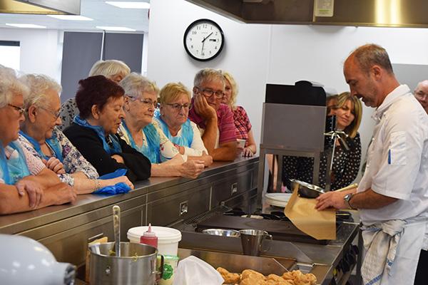Retirement Living residents with Chef in kitchens